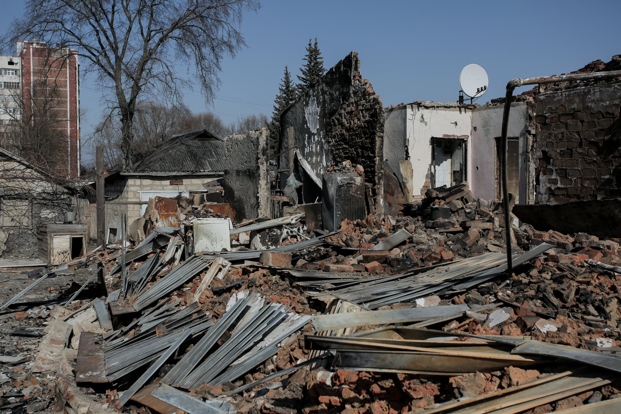 Разрушенные, обгоревшие жилые дома и груды обломков кирпича и металла после обстрела.